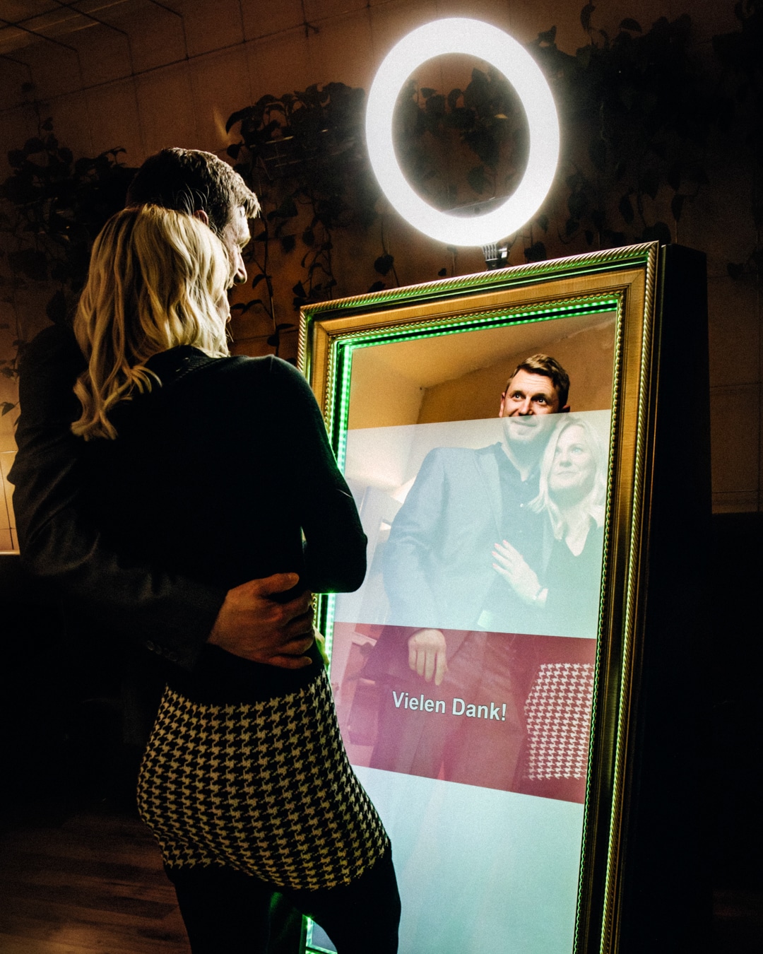 Fotospiegel (Fotobox) von Glüx mit einem Paar, das ein gemeinsames Erinnerungsfoto erstellt, umrahmt von einer stilvollen, beleuchteten Einfassung in einer eleganten Event-Umgebung in Bayreuth.