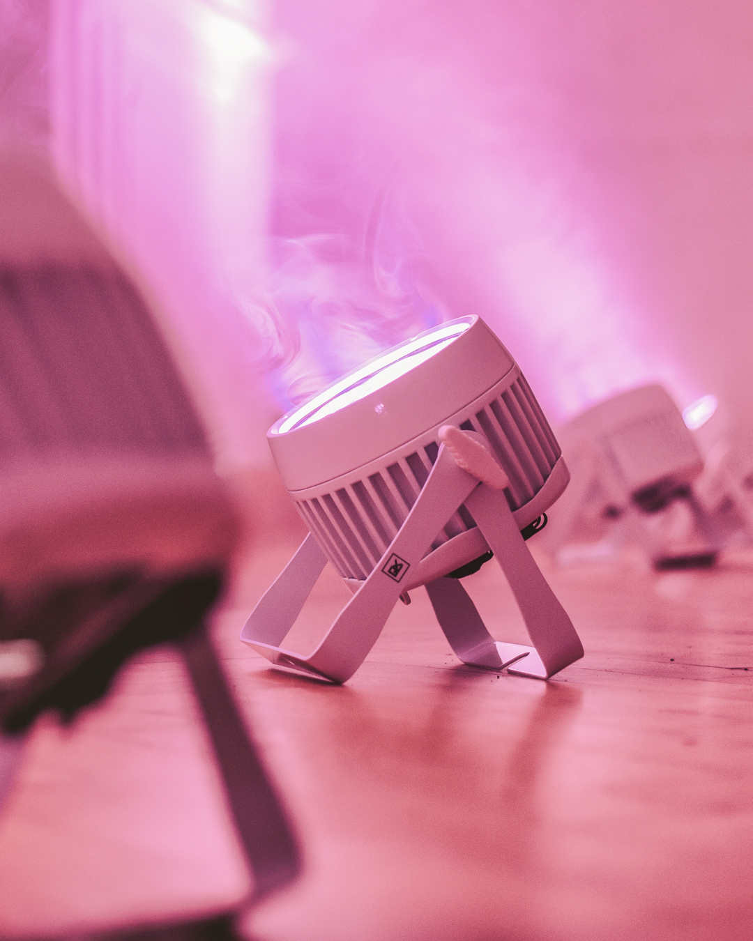 Ein moderner LED_Scheinwerfer erzeugt ein atmosphärisches pinkes Licht, das den Raum in ein warmes Ambiente taucht.
