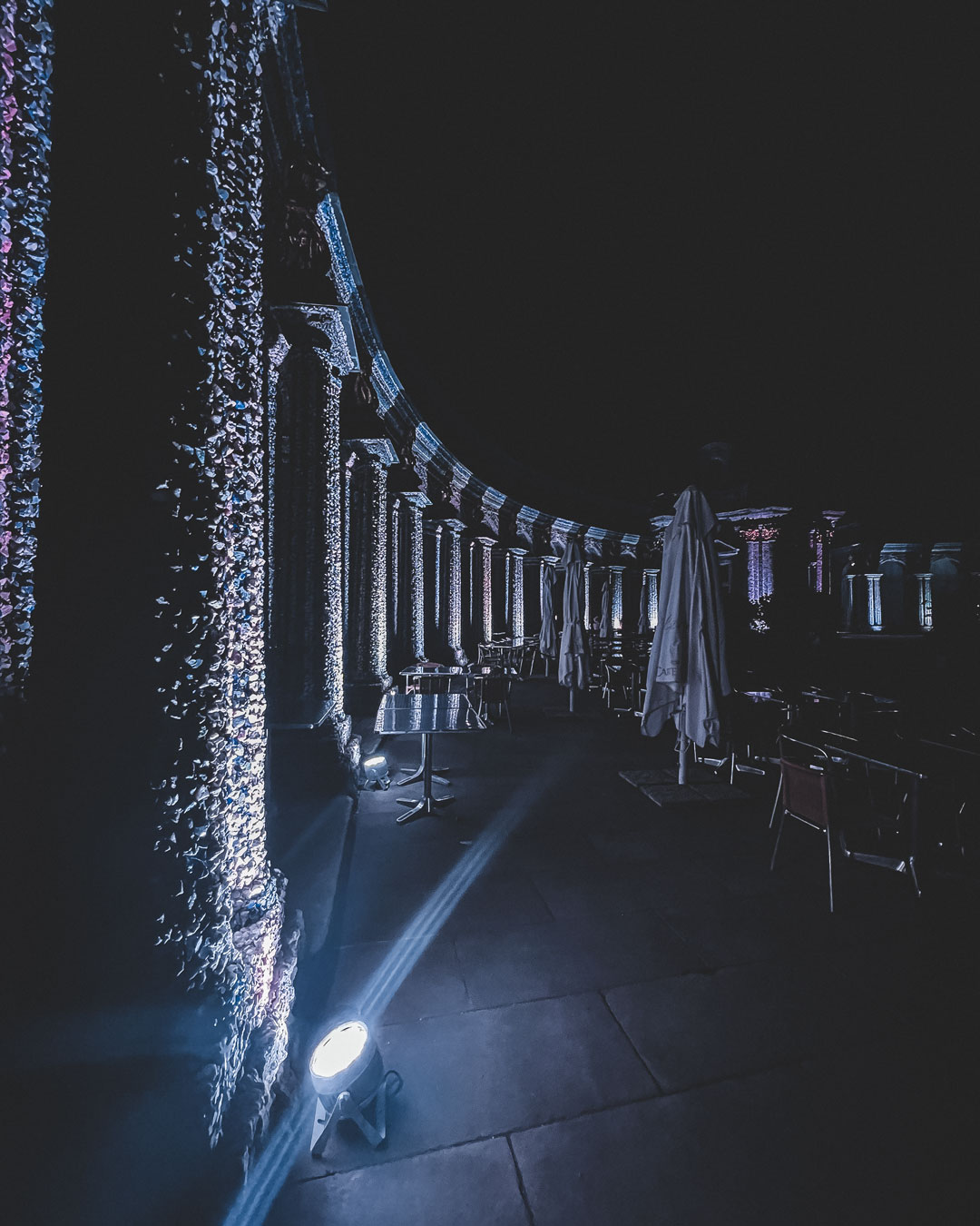 Nächtliche Illumination am Schloss Eremitage in Bayreuth mit funkelnden Lichtern, die die Architektur betonen und einem beleuchteten Pfad, der zu Tischen und Stühlen führt.